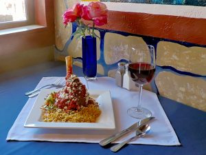 Entrees at Jake and Telly's: Lamb Shank (Arní Giouvétsi). A close up photo of our Colorado lamb shank, braised in our house-made Greek tomato sauce. Served with herbed orzo, Feta cheese, and sautéed vegetables.
