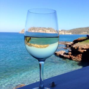 Greek Wine: a glass of white wine at the ocean